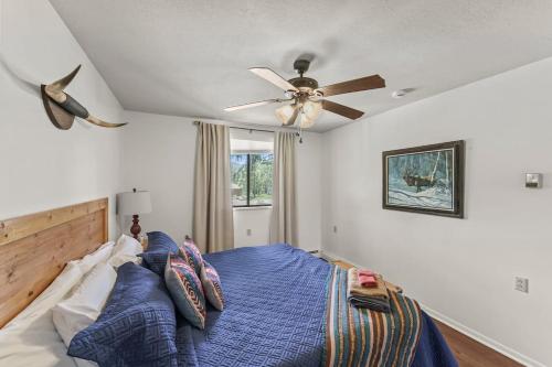 Schlafzimmer mit einem Bett und einem Deckenventilator in der Unterkunft Rustic Mountain Getaway~Golf~Skiing~Hiking in Angel Fire