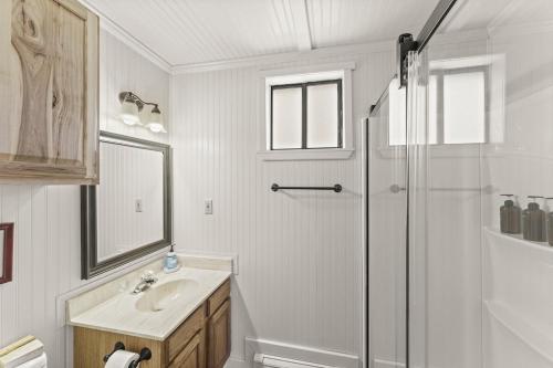 ein weißes Bad mit einer Dusche und einem Waschbecken in der Unterkunft Rustic Mountain Getaway~Golf~Skiing~Hiking in Angel Fire