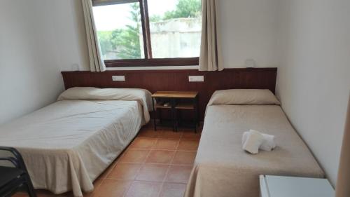 2 Betten in einem Zimmer mit Fenster in der Unterkunft Hostal Jadraza in Zahara de los Atunes