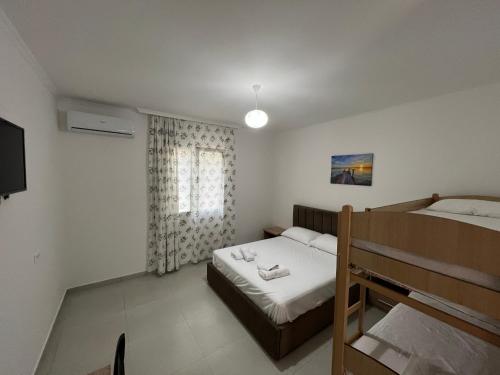 Habitación pequeña con cama y ventana en Hotel Paradise, en Fshati i Ri