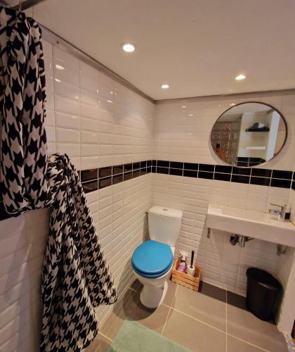bagno con servizi igienici blu e lavandino di Chambre Deborah a Le Pradet