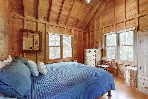 a bedroom with a blue bed in a wooden cabin at Charming South Bristol Cottage in South Bristol