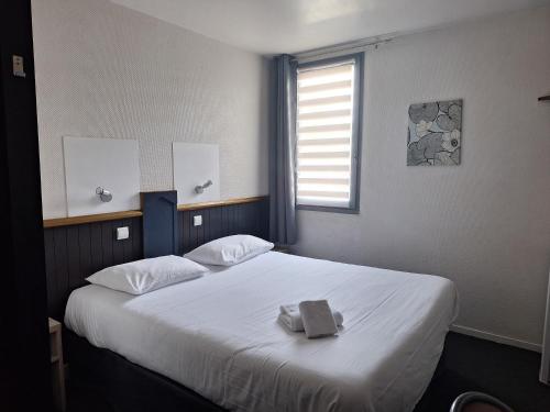 Un dormitorio con una cama con una toalla. en Escale Kennedy en Mérignac
