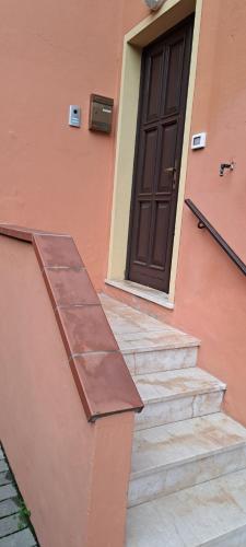 a building with a brown door and some stairs at APPARTAMENTO SERENA in Bagnolo Mella