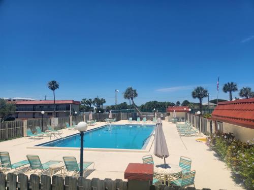een zwembad met stoelen en parasols in een resort bij A1A Brownwaves in St. Augustine