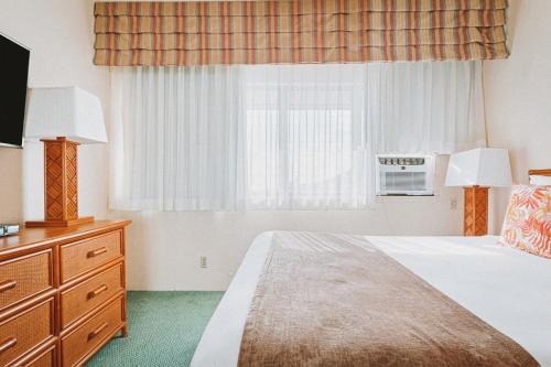 a hotel room with a bed and a window at Banyan Harbor Resort in Lihue