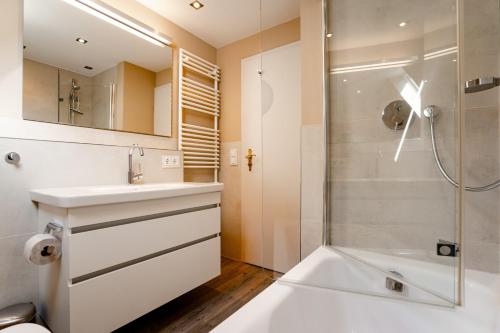 a bathroom with a sink and a shower at Sylter Seestern Haus Nösseblick in Morsum