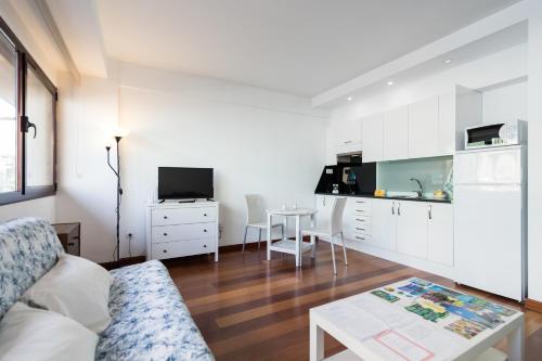 ein Wohnzimmer mit einem Sofa und einem Tisch in der Unterkunft Loft moderno y cómodo a un minuto de Las Canteras in Las Palmas de Gran Canaria