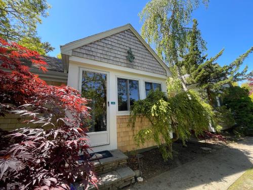 a small house with a white door and windows at Pleasant Bay Village Resort in Chatham