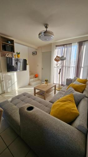 ein Wohnzimmer mit einer grauen Couch und gelben Kissen in der Unterkunft Casa Recidencial M&H in Emiliano Zapata