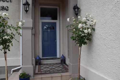 a blue door on a house with flowers in front at One Marine Place in Port Bannatyne