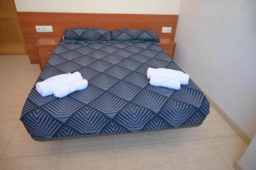 1 dormitorio con 1 cama y 2 toallas blancas en Oliva Mar, en Lloret de Mar