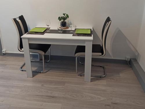 a white table with three chairs and a plant on it at Relais De La Tour in Callac
