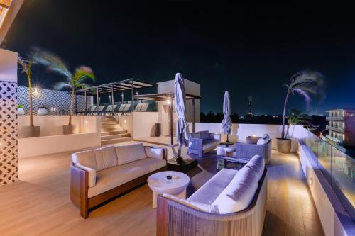 a living room with couches and chairs on a balcony at Coralia Boutique Hotel Cozumel in Cozumel