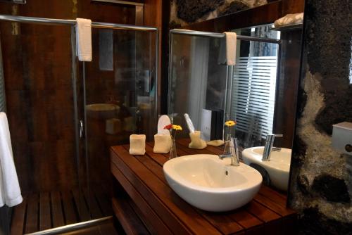 ein Bad mit einem Waschbecken und einer Dusche in der Unterkunft Casa da Ermida in Velas
