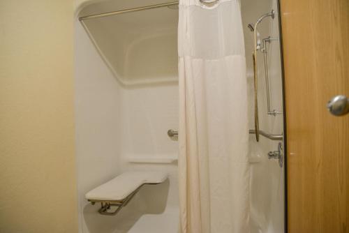 een badkamer met een douche met een wit douchegordijn bij Days Inn by Wyndham Mount Vernon in Mount Vernon