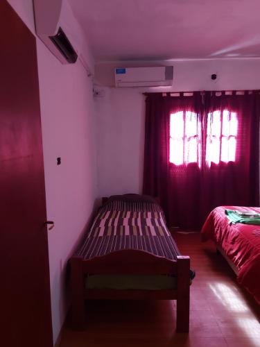 een slaapkamer met 2 bedden en rode gordijnen bij Posada Chaupihuasi in Villa Unión