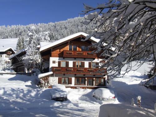 a wooden house in the snow with snow covered trees at Haus Zauner in Reit im Winkl