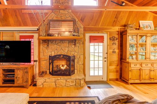a living room with a stone fireplace in a house at Tumbling Shoals Cabin Less Than 1 Mi to Beaches and Boating! in Heber Springs