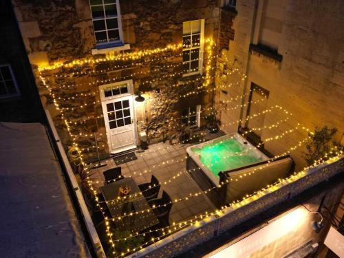 an outdoor patio with lights and a swimming pool at Dream Stays Bath - Trim Street Townhouse with Hot tub in Bath