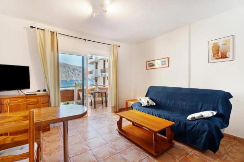 a living room with a blue couch and a table at Apartamento La Playa in Valle Gran Rey