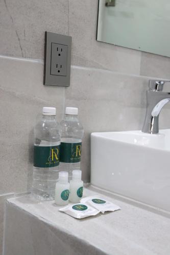 a bathroom counter with two bottles of water and a sink at Hotel Riviera in San Juan de los Lagos