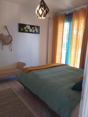 une chambre avec un lit vert et une fenêtre dans l'établissement MAISON de VACANCES, à Seyresse