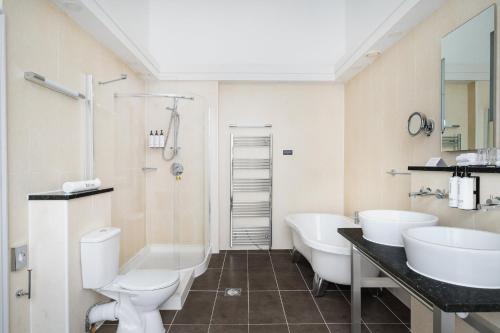 a bathroom with two sinks and two toilets at voco Edinburgh - Royal Terrace by IHG in Edinburgh
