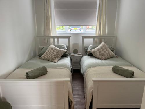 two beds in a small room with a window at Channel View in Weston-super-Mare
