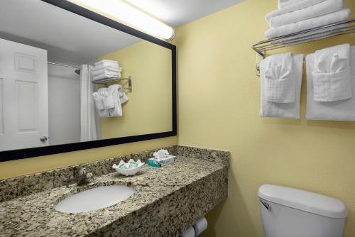 a bathroom with a sink and a mirror and a toilet at Best Western Ocean Sands Beach Resort in Myrtle Beach