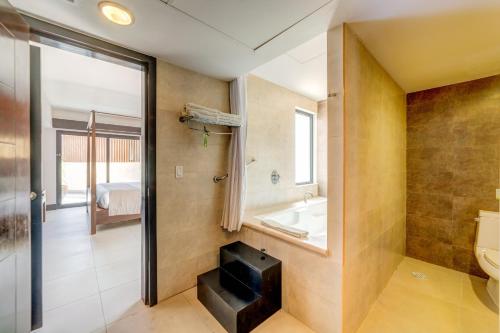 ein Badezimmer mit einer Badewanne, einem WC und einem Waschbecken in der Unterkunft Aldea Thai by Mistik Vacation Rentals in Playa del Carmen
