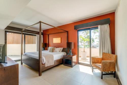 ein Schlafzimmer mit einem Bett mit einer orangefarbenen Wand in der Unterkunft Aldea Thai by Mistik Vacation Rentals in Playa del Carmen