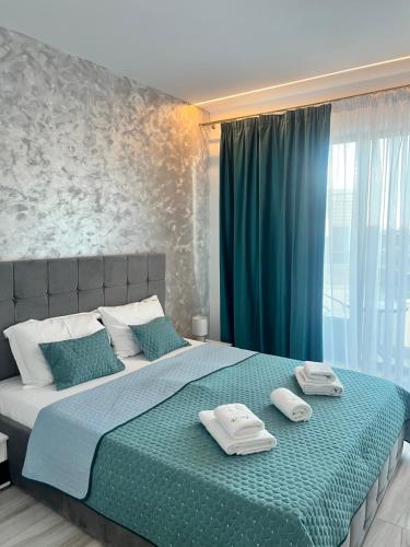a bedroom with a large bed with two towels on it at Bel Air Mamaia Nord Complex - Apartament Delux in Mamaia