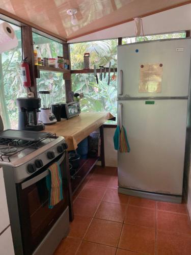 德雷克的住宿－Casita Corcovado，厨房配有冰箱和炉灶。