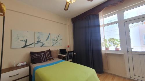 a bedroom with a green bed and a window at Feeling at home in İstanbul Center 5 Minutes walk to The Ataköy Metro Station & Metrobus in Istanbul
