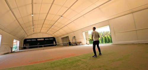 a man standing on a tennis court with a racket at Pension Patrik in Hrušica