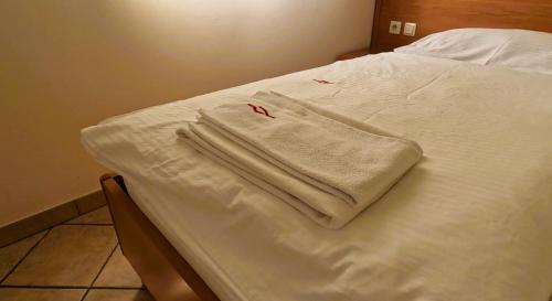 un asciugamano bianco seduto sopra un letto di Pension Patrik a Hrušica