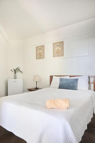 a white bed with a towel on top of it at Perla de la Playa Beachfront Hotel in Tamarindo