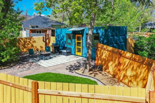 a blue and yellow house with a fence at Cargo Casita Shipping Container Tiny Home in Colorado Springs
