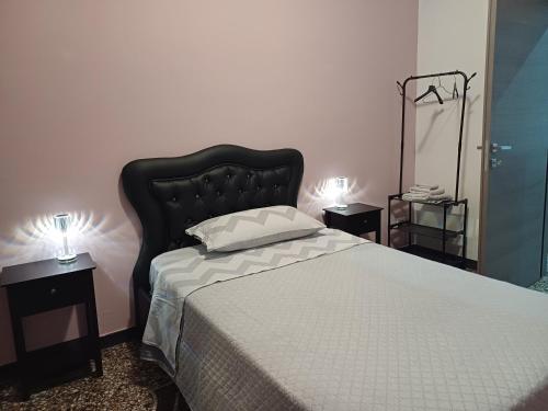 a bedroom with a bed with a black headboard and two lamps at Casa Sole E Luna in Genova