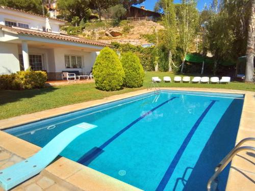 a swimming pool in front of a house at Villa Max in Lloret de Mar