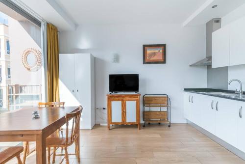 Il comprend une cuisine et une salle à manger avec une table et une télévision. dans l'établissement Loft moderno con balcón al lado de Las Canteras, à Las Palmas de Gran Canaria