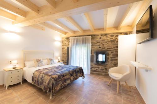 ein Schlafzimmer mit einem Bett und einem Stuhl in einem Zimmer in der Unterkunft Landras de Compostela in Santiago de Compostela