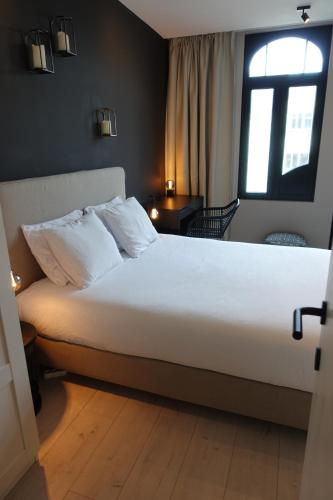 a bedroom with a large white bed with a window at 3 Room Luxury Design Apartment with Airconditioning, Close to Gent St-Pieters Station in Ghent