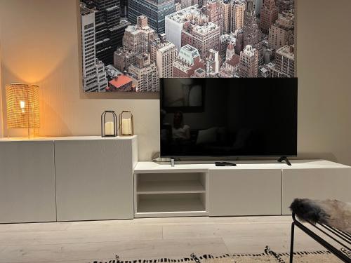 een woonkamer met een wit entertainmentcentrum met een grote televisie bij 3 Room Luxury Design Apartment with Airconditioning, Close to Gent St-Pieters Station in Gent
