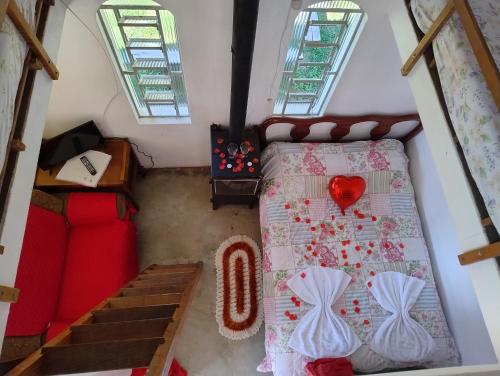 a attic bedroom with a bed and a couch at Chalé doce beija-flor in Campos do Jordão