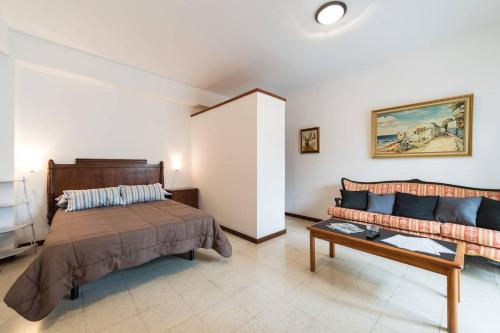a bedroom with a bed and a couch at Loft luminoso y espacioso al lado de Las Canteras in Las Palmas de Gran Canaria