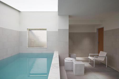 a bathroom with a swimming pool and a table and chairs at Hotel La Villa Saint Germain Des Prés in Paris