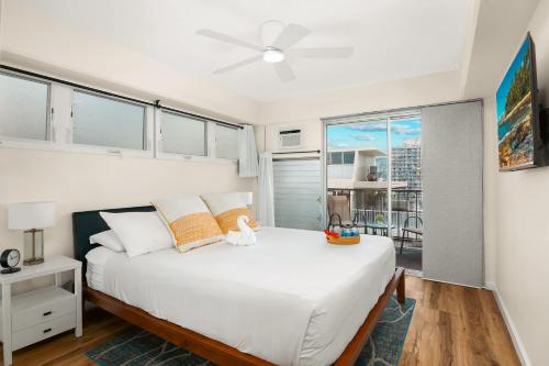 ein Schlafzimmer mit einem großen weißen Bett mit einem Fenster in der Unterkunft 2BR-2BA Close to Waikiki Beach with Free Parking! in Honolulu