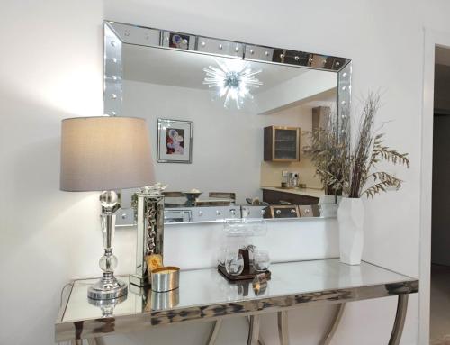 uma mesa com um candeeiro e um espelho em Exclusivo apartamento con Jacuzzy K103 em Punta Cana